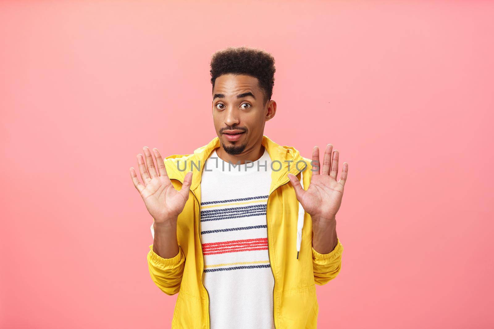 Guy staying out of troubles. Portrait of confused unsure clueless african american guy with beard raising palms in surrender gazing innocent at camera denying everything being unvinvolved.