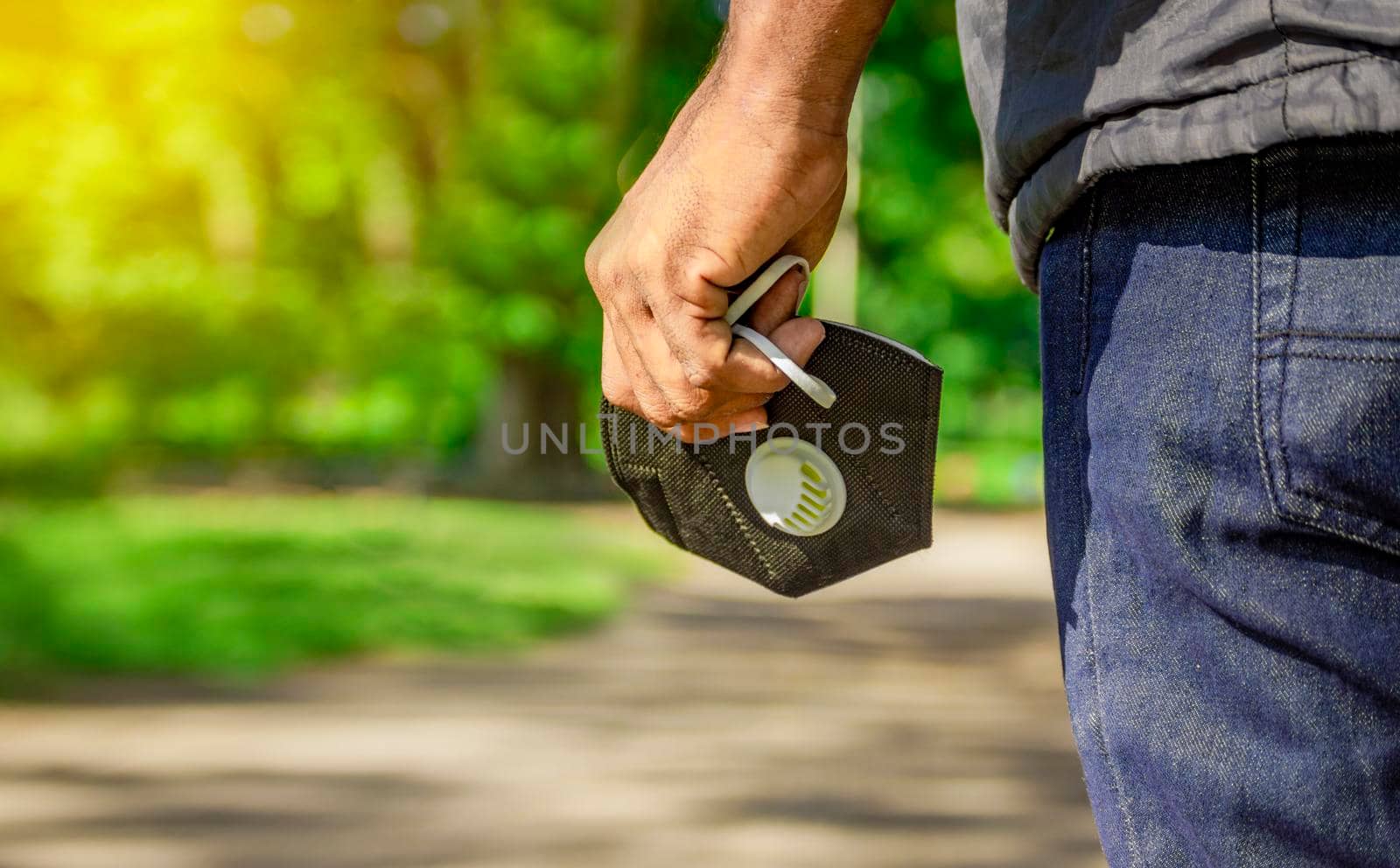 Close up of a hand holding a mask, hand holding mask with unfocused background, concept of mask use