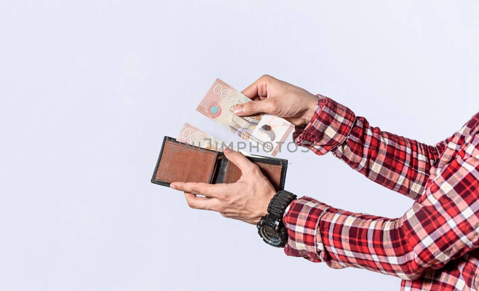 Man taking money out of his wallet, close up of hands taking money out of his wallet isolated, Nicaraguan banknotes, cash payment concept
