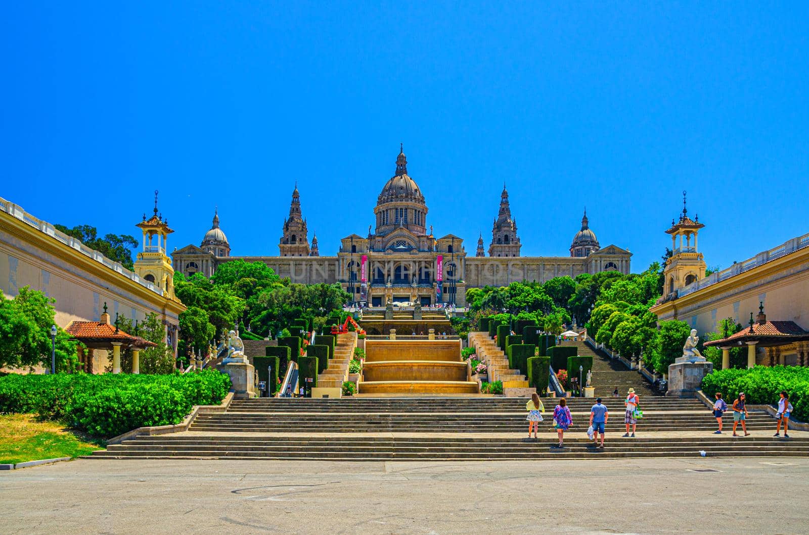 Barcelona, Spain, June 12, 2017: Palau Nacional or National Palace of Montju c and National Art Museum of Catalonia and walking tourists in historical city centre, blue sky in sunny day background