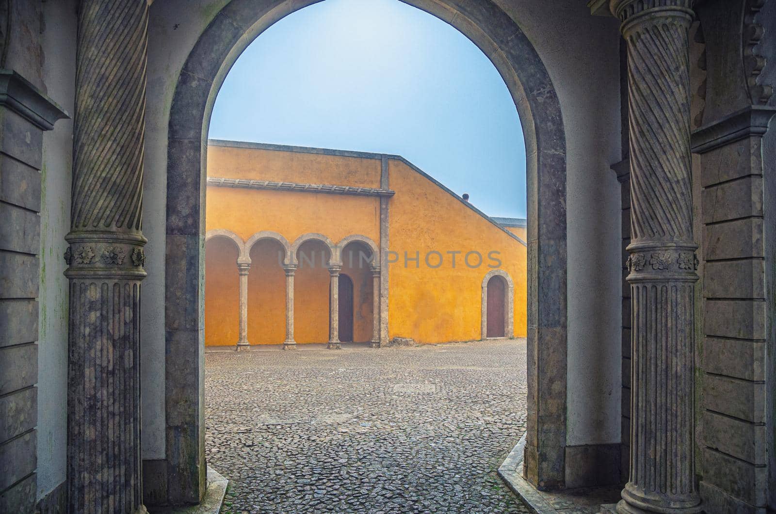 Sintra, Portugal, June 14, 2017: cobblestone courtyard of Pena Palace with arches and columns, Palacio Nacional da Pena Romanticist castle in Sao Pedro de Penaferrim