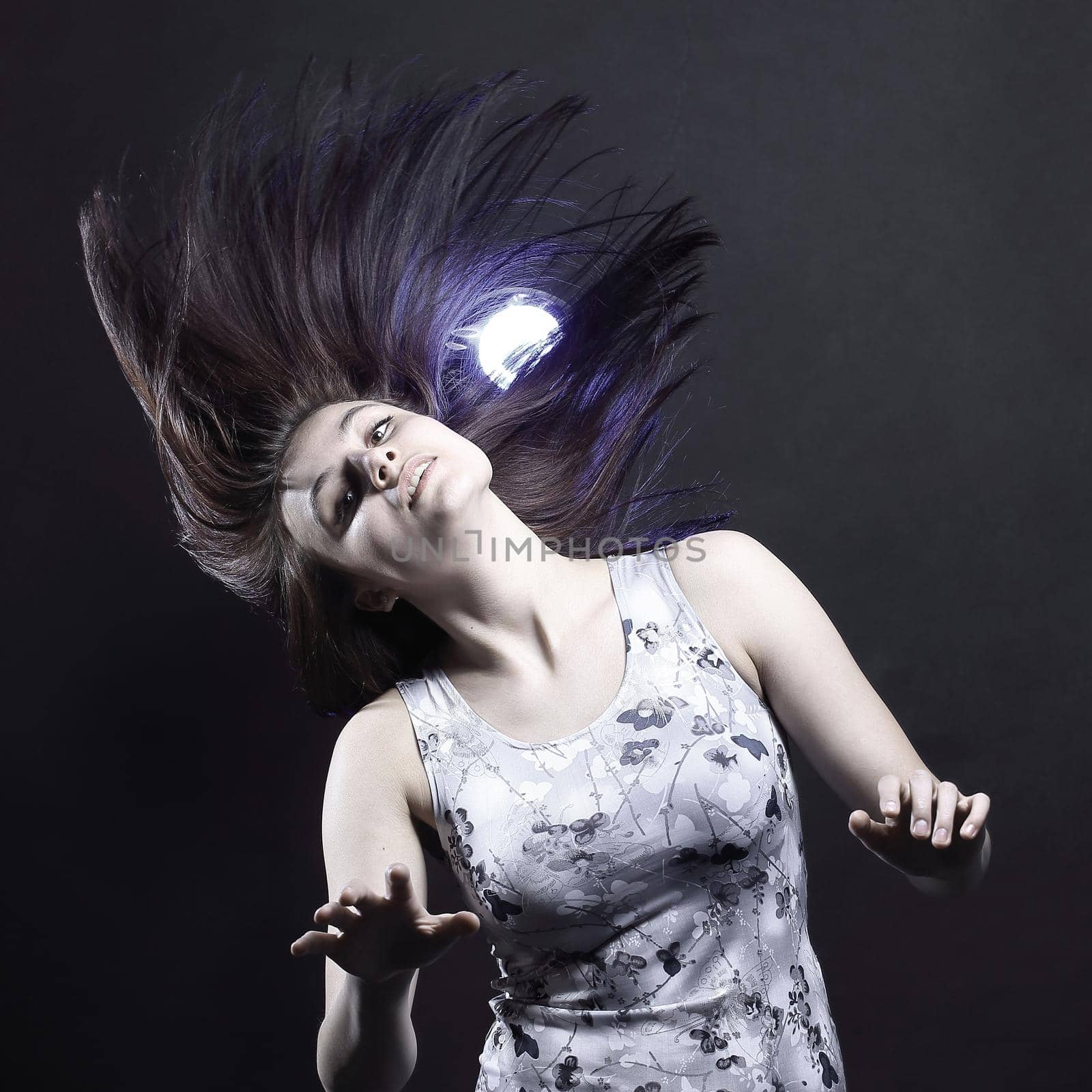 Portrait of young attractive brunette woman with black backdrop.