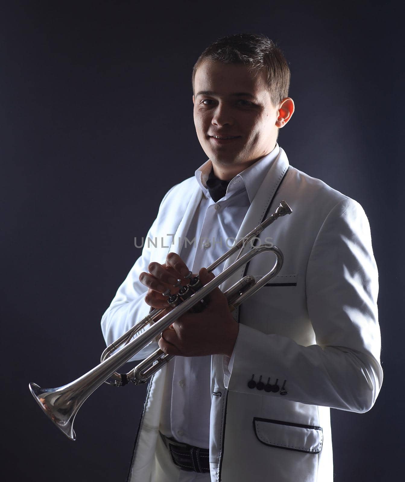 young man in a white suit with a trumpet.isolated on black background by SmartPhotoLab