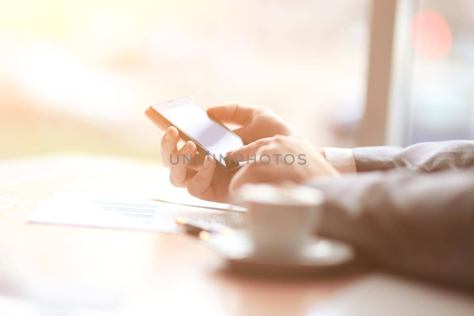 close up.the businessman uses a smartphone sitting at his Desk .business concept