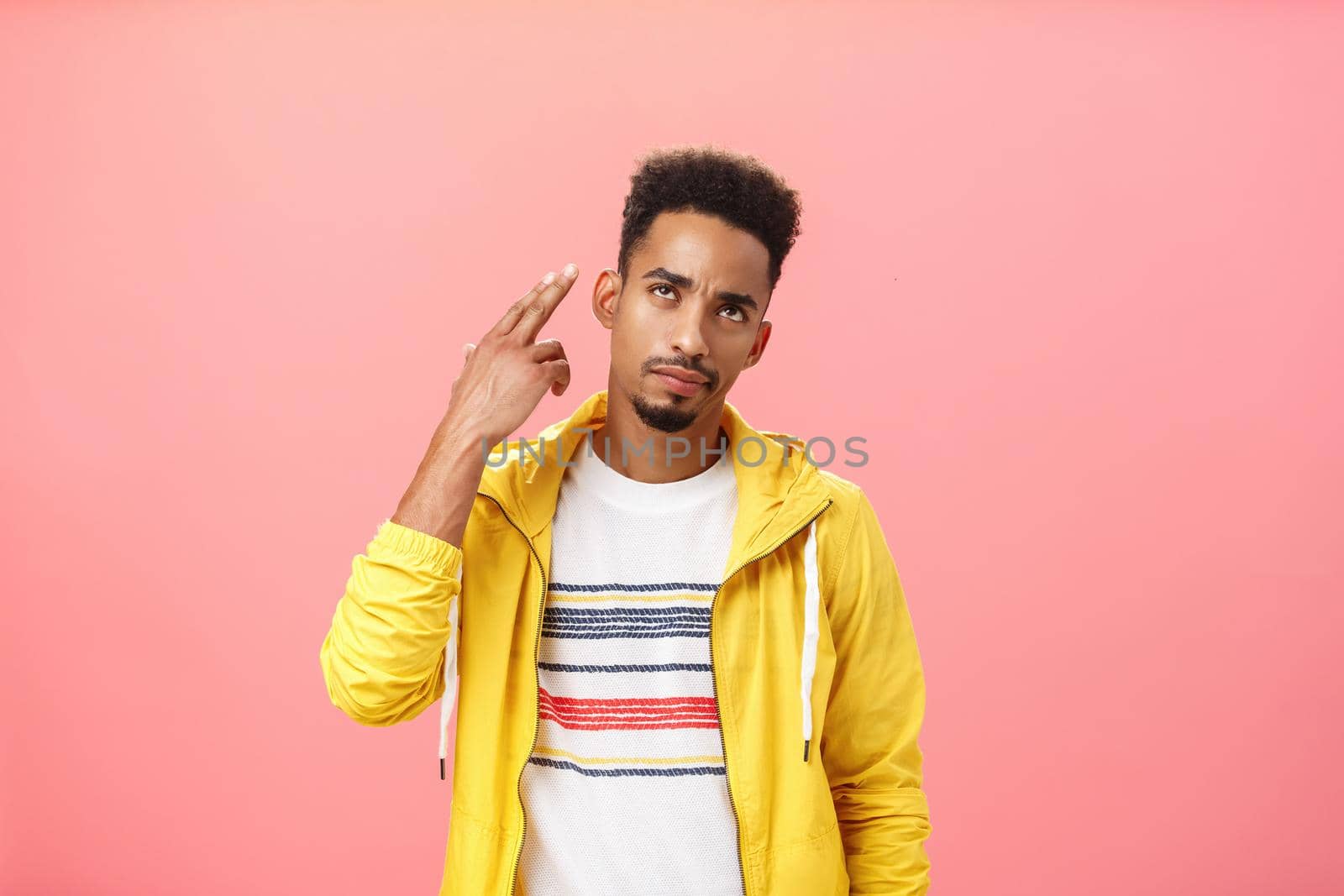 You kill my vibe. Gloomy irritated and annoyed handsome stylish african american guy in yellow trendy jacket showing finger gun gesture over temple as if shooting himself with bothered look.