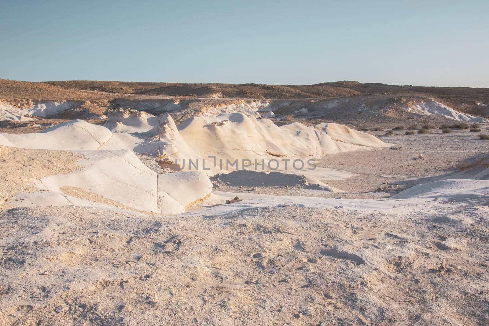 Beautiful lunar landscape. Wight and smooth hills in various shapes in a desert landscape. The whitish, rounded, winding, and smooth chalk rocks. Israel. High quality photo