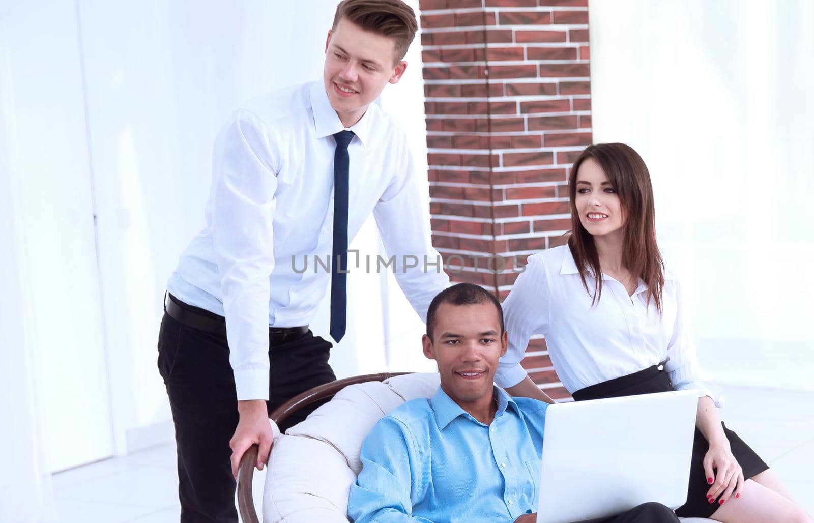 successful businessman with his assistants in a discussion of the information from the laptop.office life