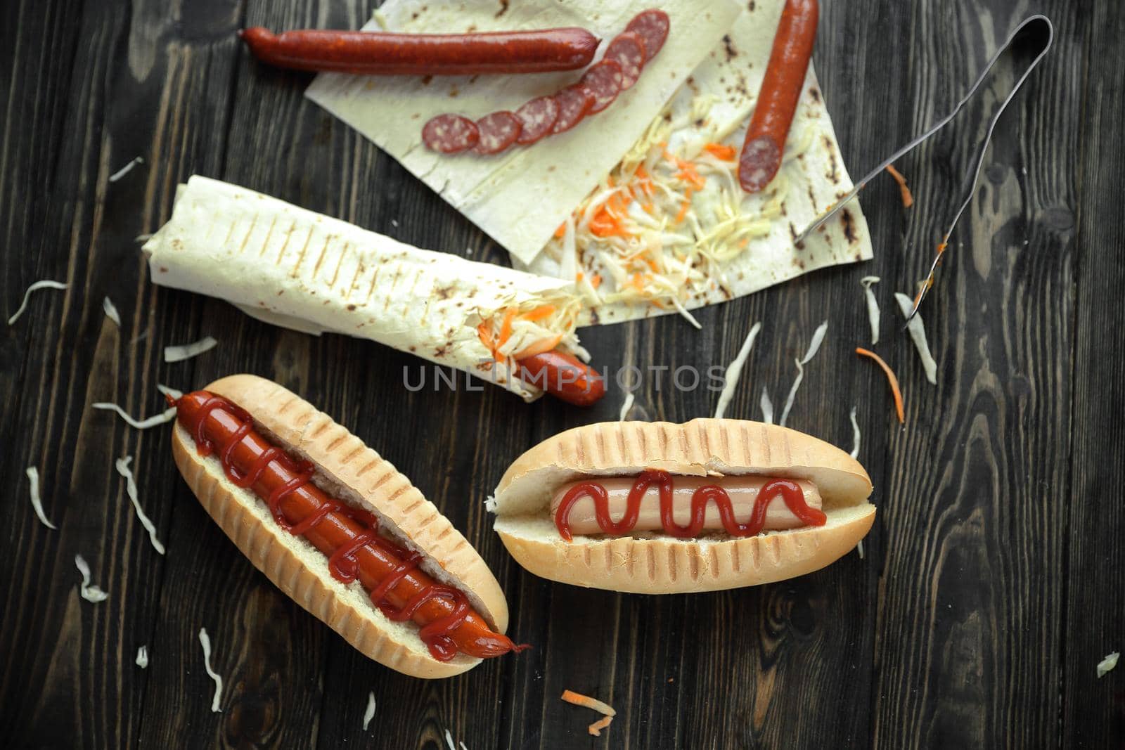 fast food.sausage in pita bread and hot dog on wooden background.