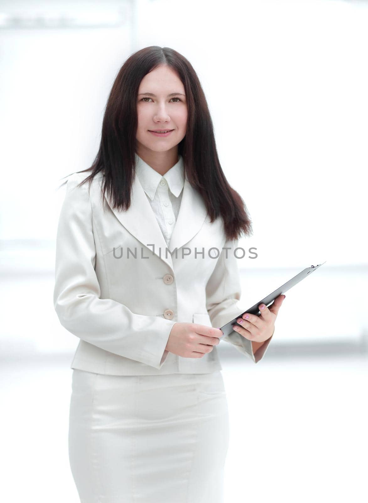 elegant business woman with clipboard on light office background by SmartPhotoLab