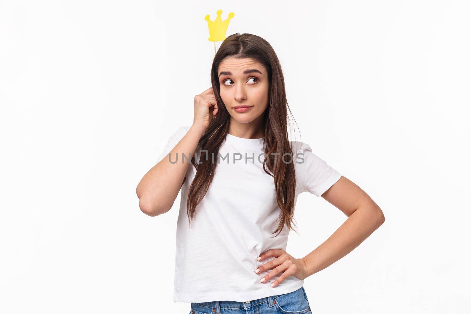 Entertainment, fun and holidays concept. Portrait of sassy and classy good-looking girl in t-shirt, holding carnaval stick with crown, acting like queen or super star, standing white background.