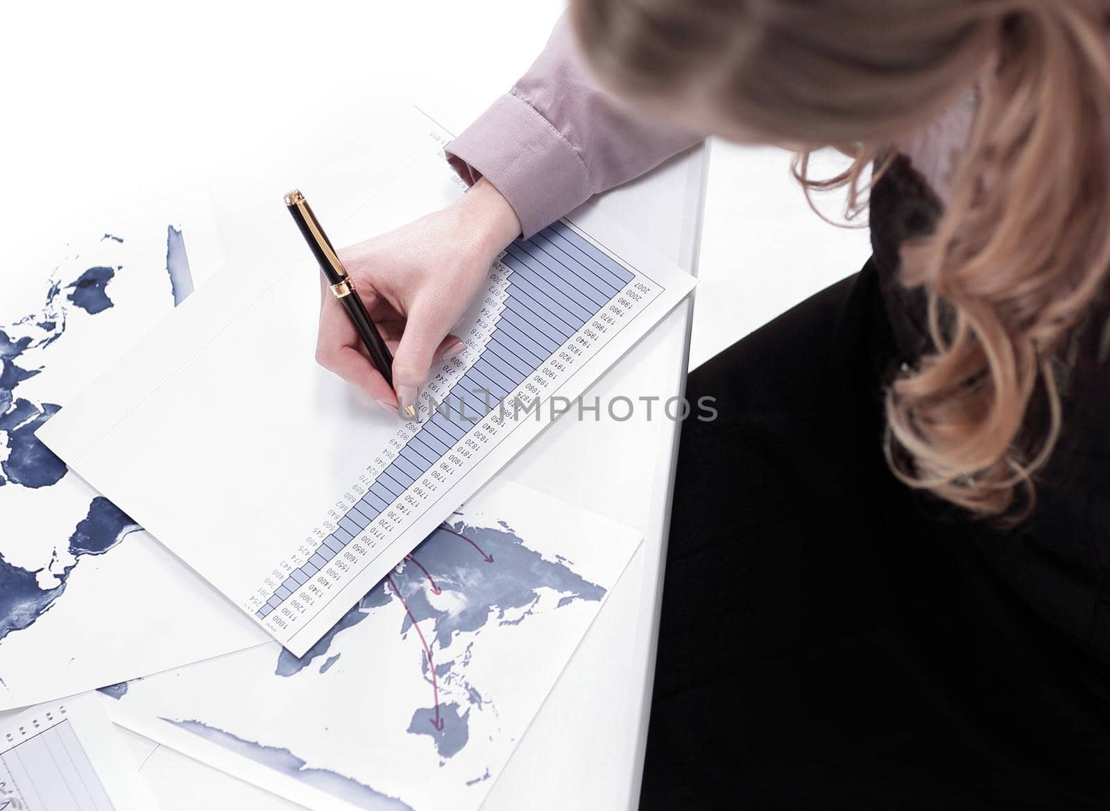 view from the top. young woman sitting at Desk and looking at camera.