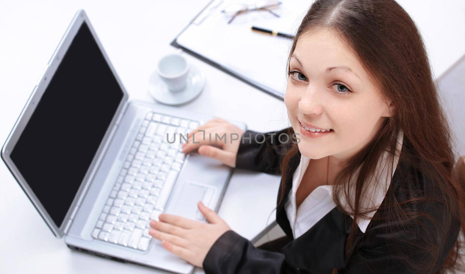 closeup.female assistant sitting at her Desk and looking at camera.