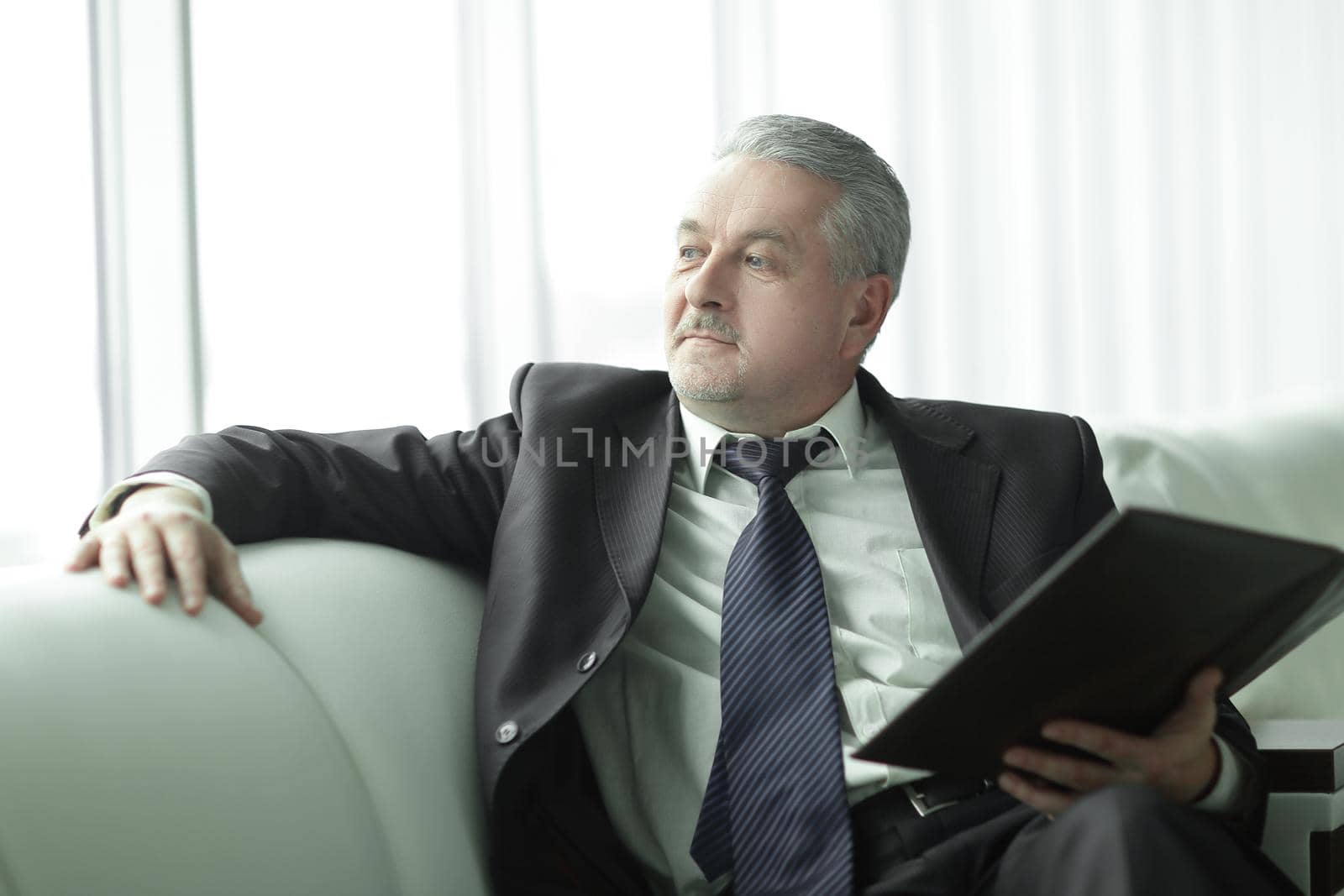 boss with clipboard sitting on the office couch.business concept by SmartPhotoLab