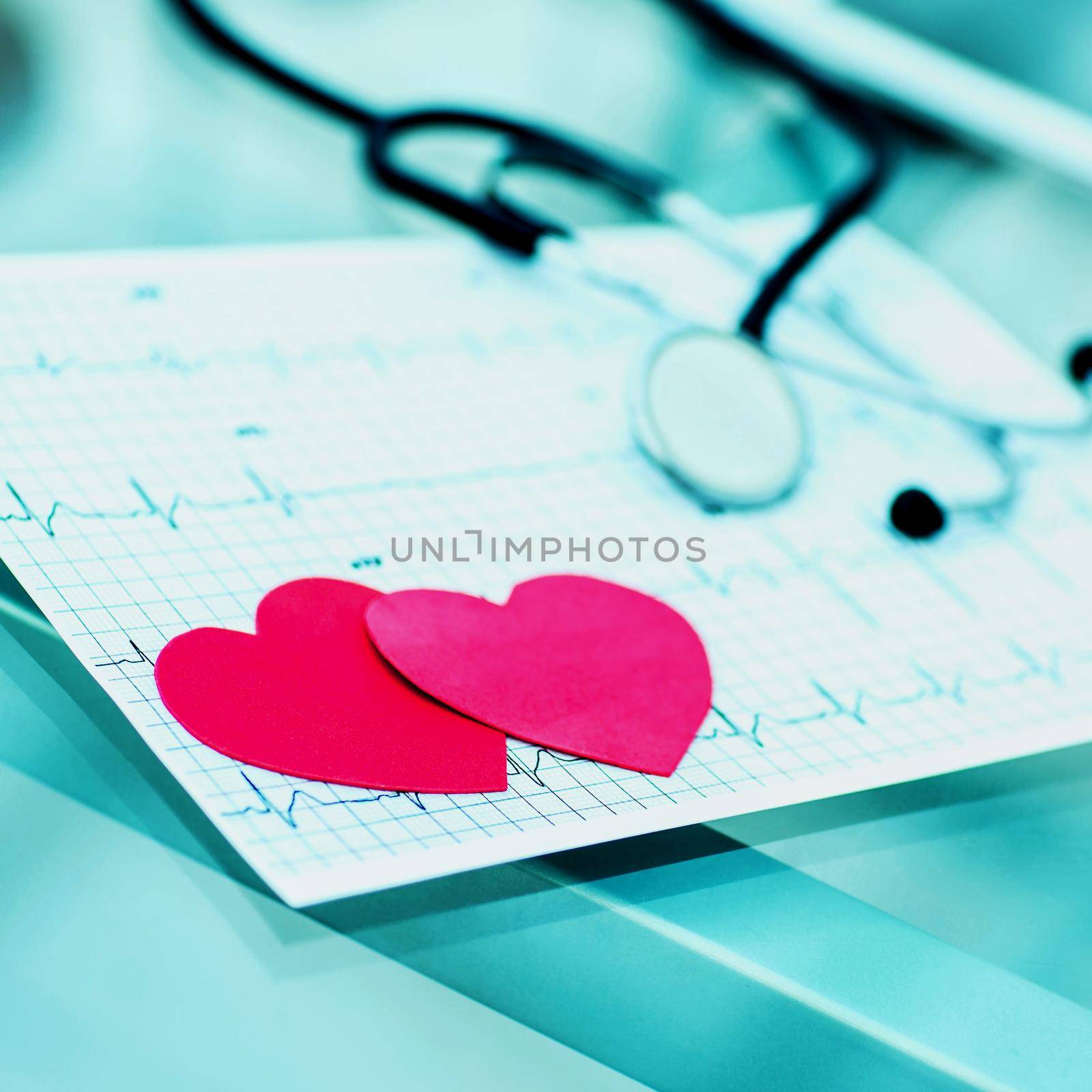 health concept: two red paper heart on the electrocardiogram, the cardiologist. by SmartPhotoLab