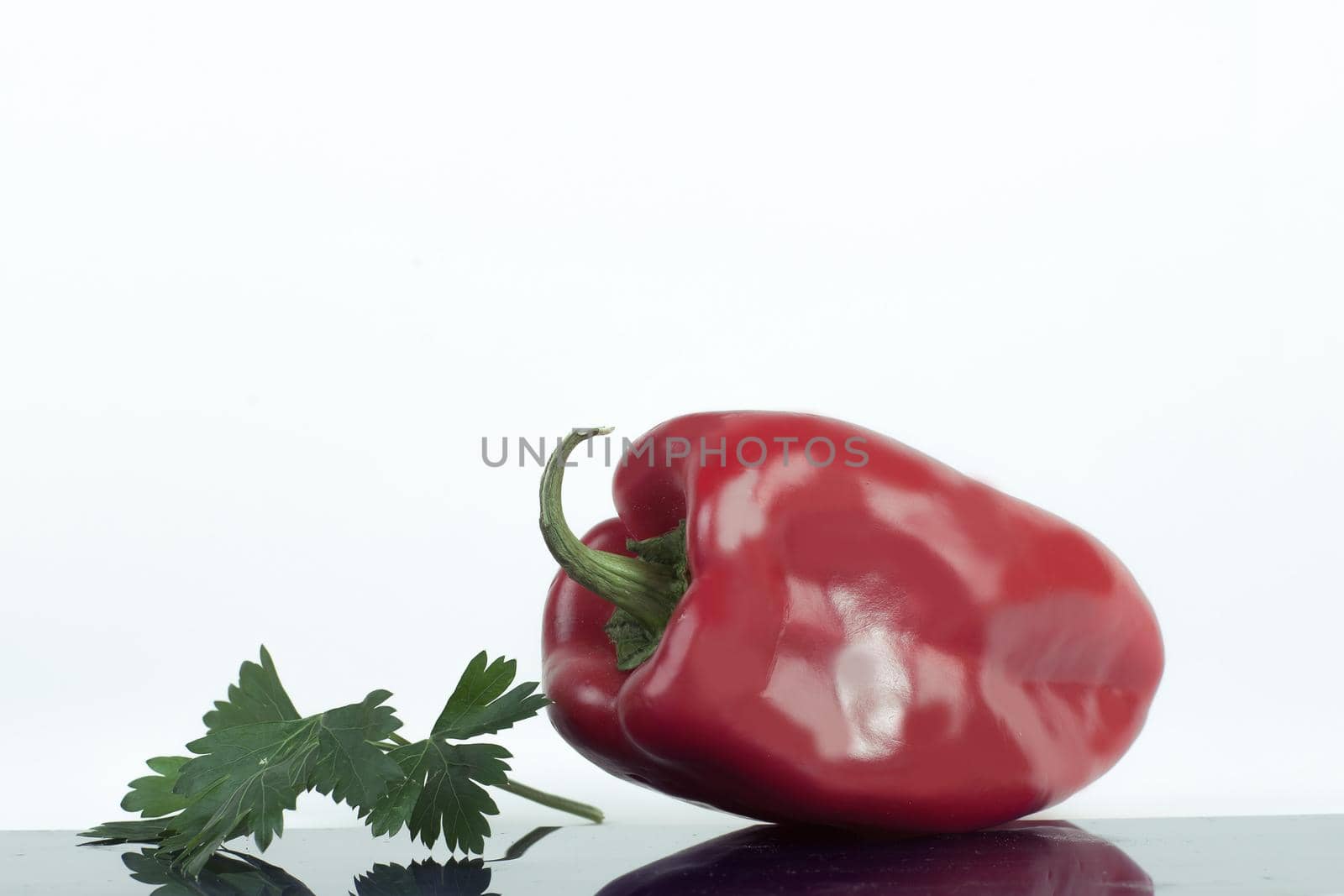 ripe bell pepper and a sprig of parsley .isolated on a white background .photo with copy space