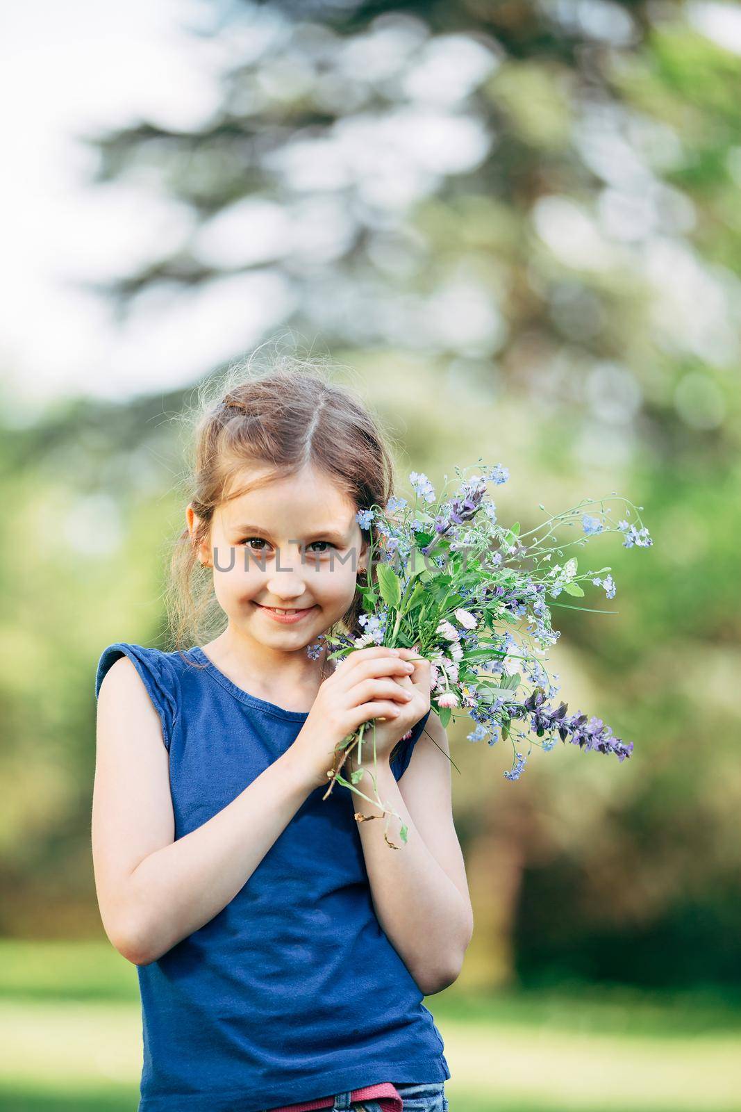 little girl with a bouquet of wildflowers. the photo has a blank space for text