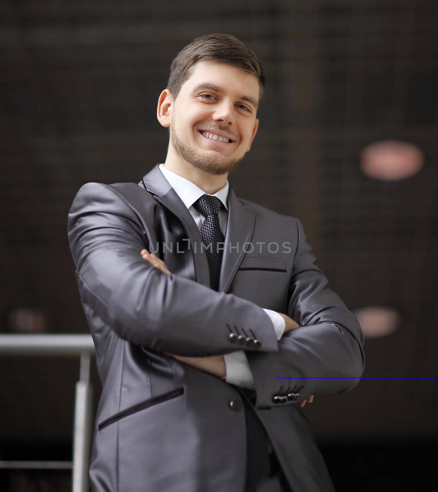 portrait of confident businessman on background of office. by SmartPhotoLab