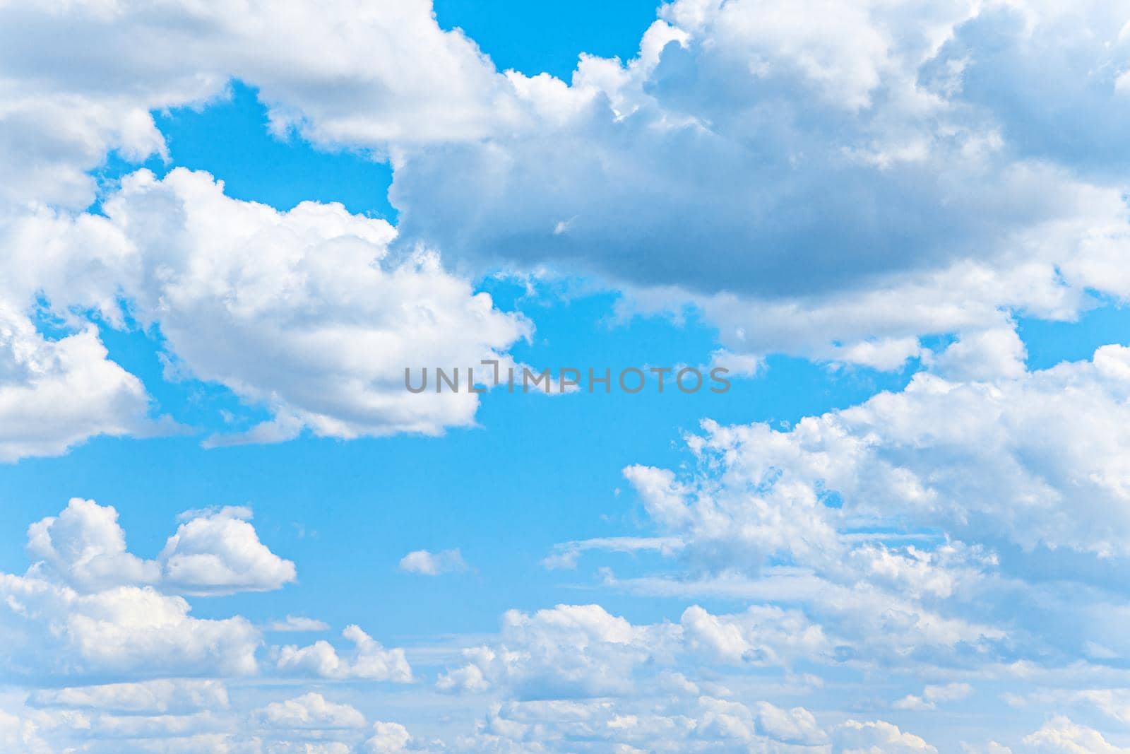 White cumulus clouds on bright blue sky by kisika