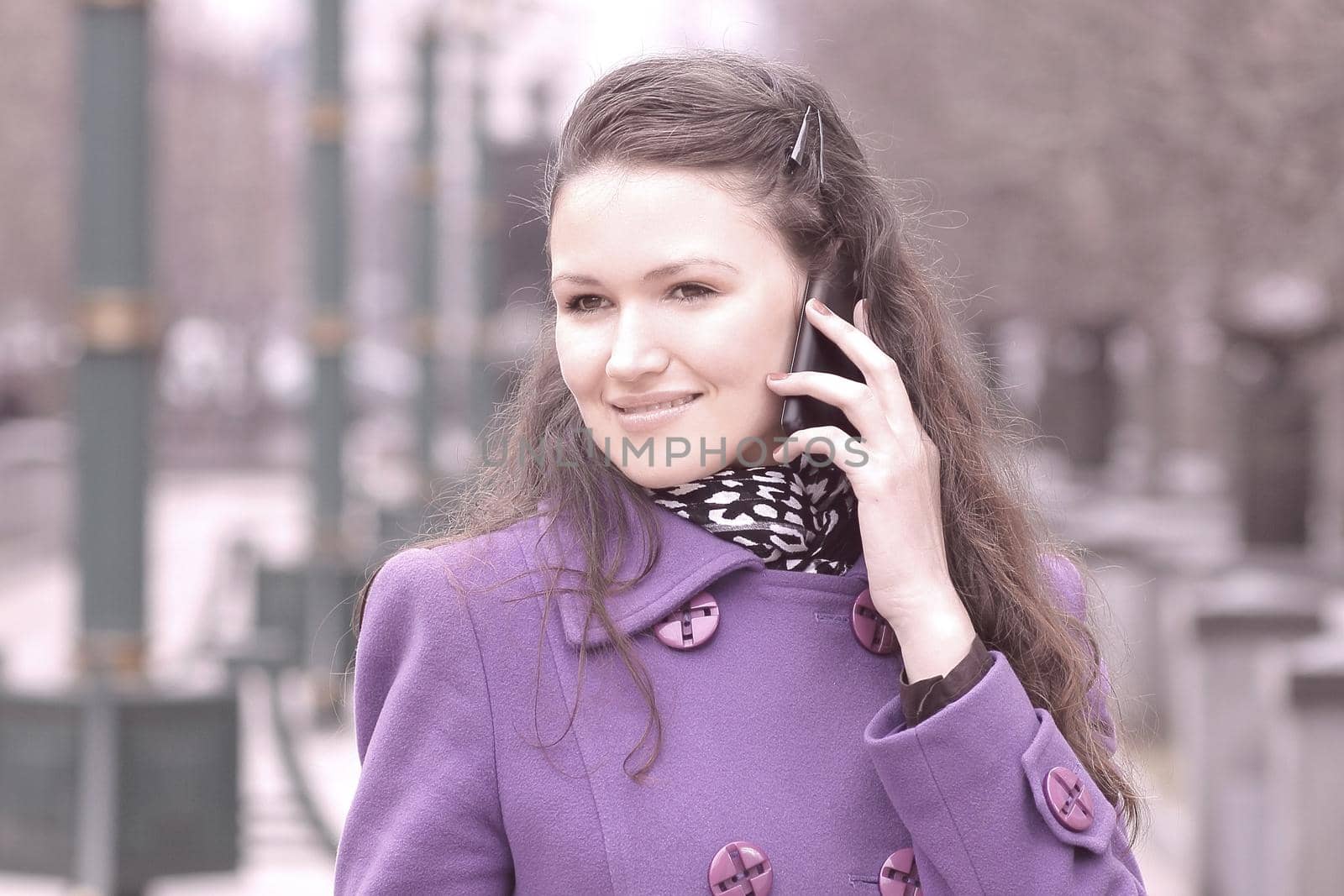 young woman talking on smartphone in city street.