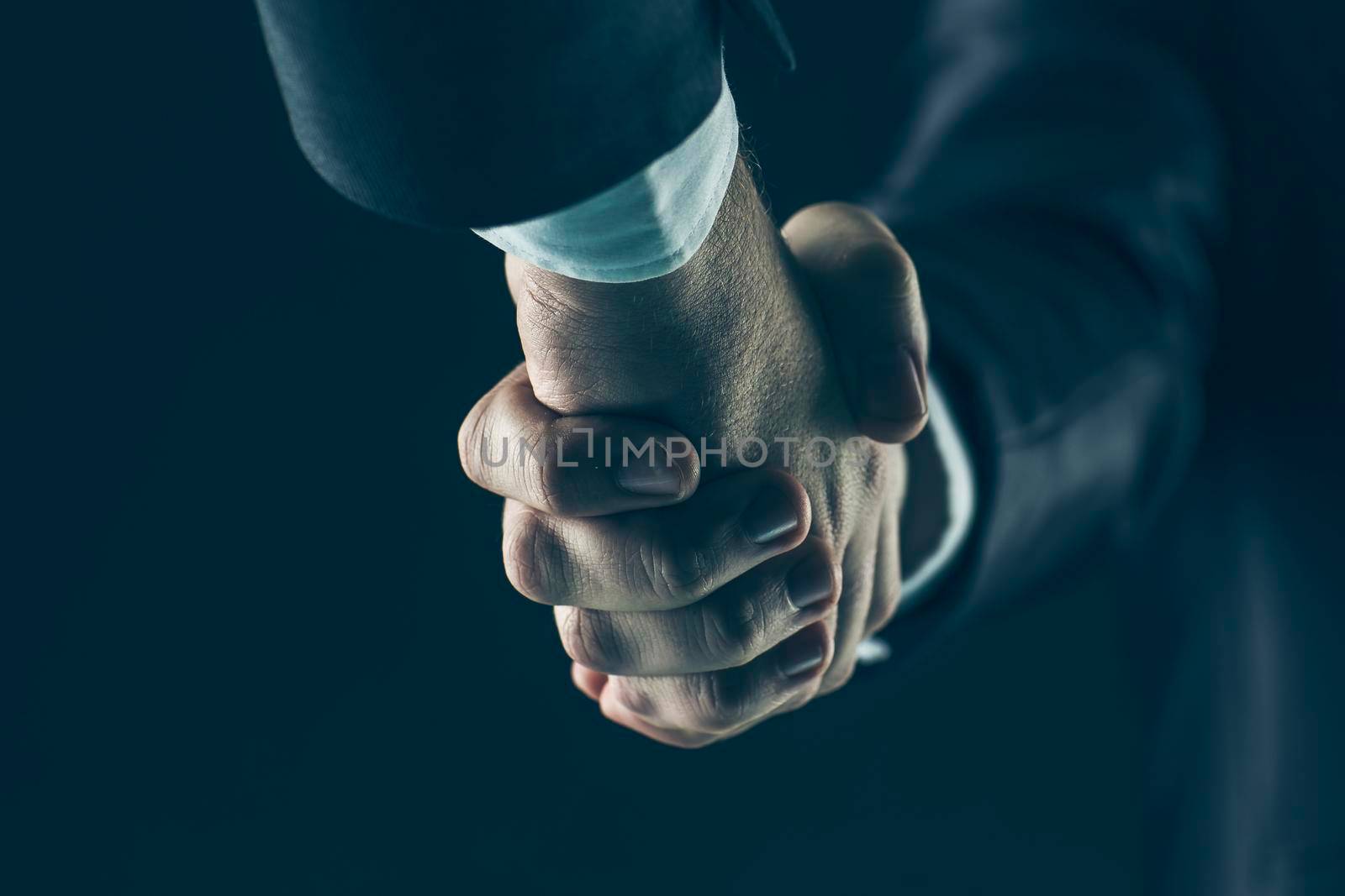 close-up of handshake of business partners on a black background.the photo has a empty space for your text