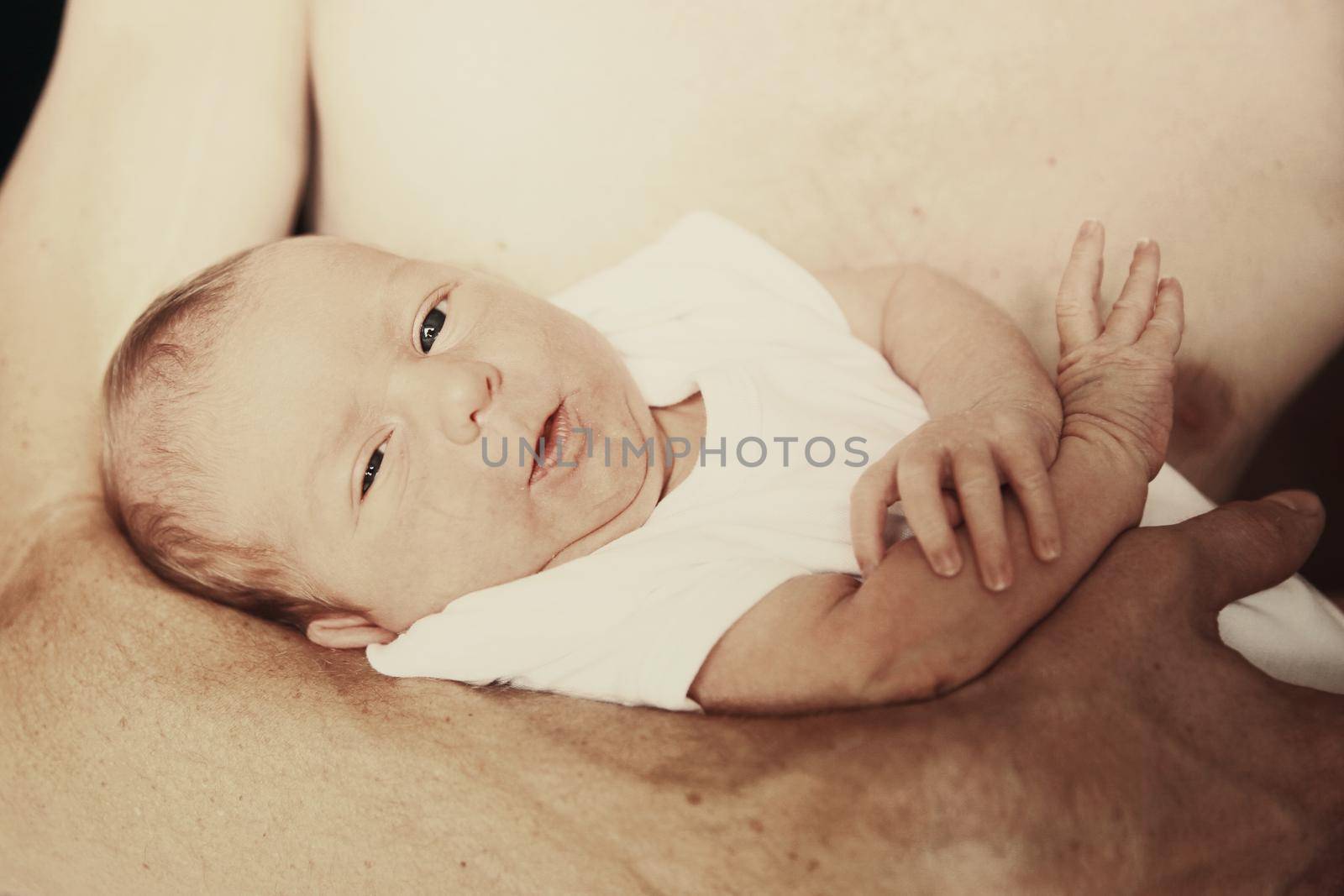 peaceful baby lying in the arms of his father