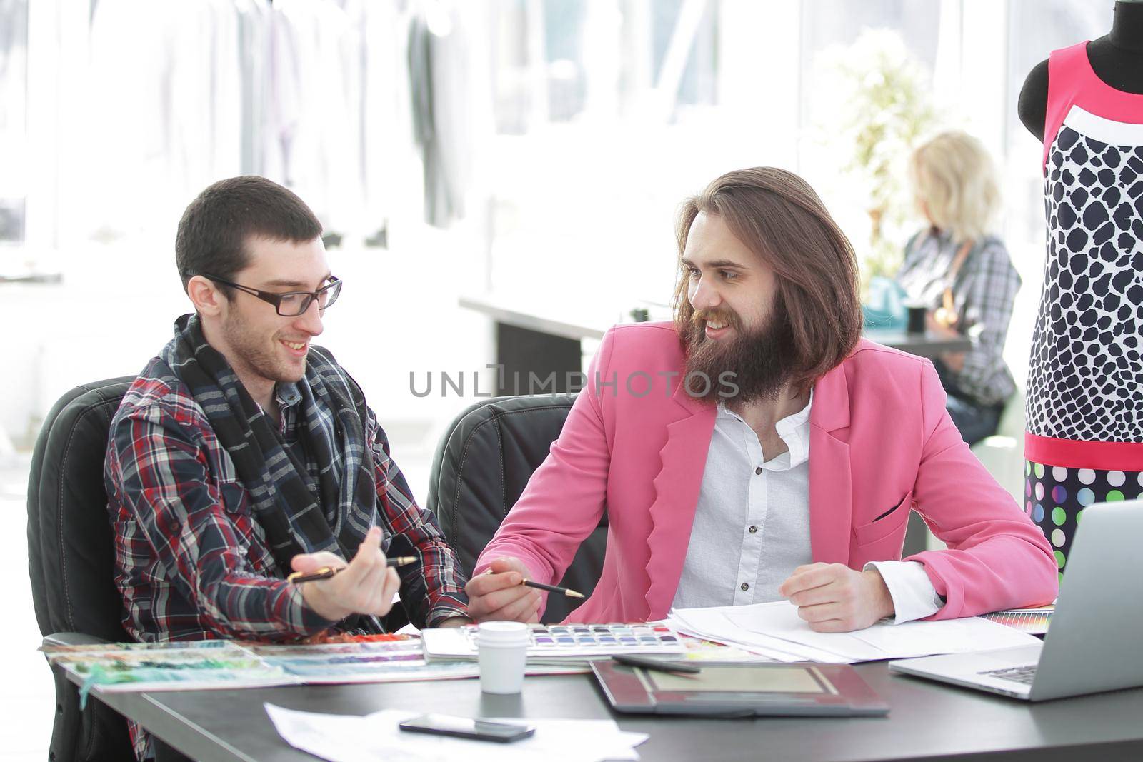 two fashion designers discussing designs of the new models.