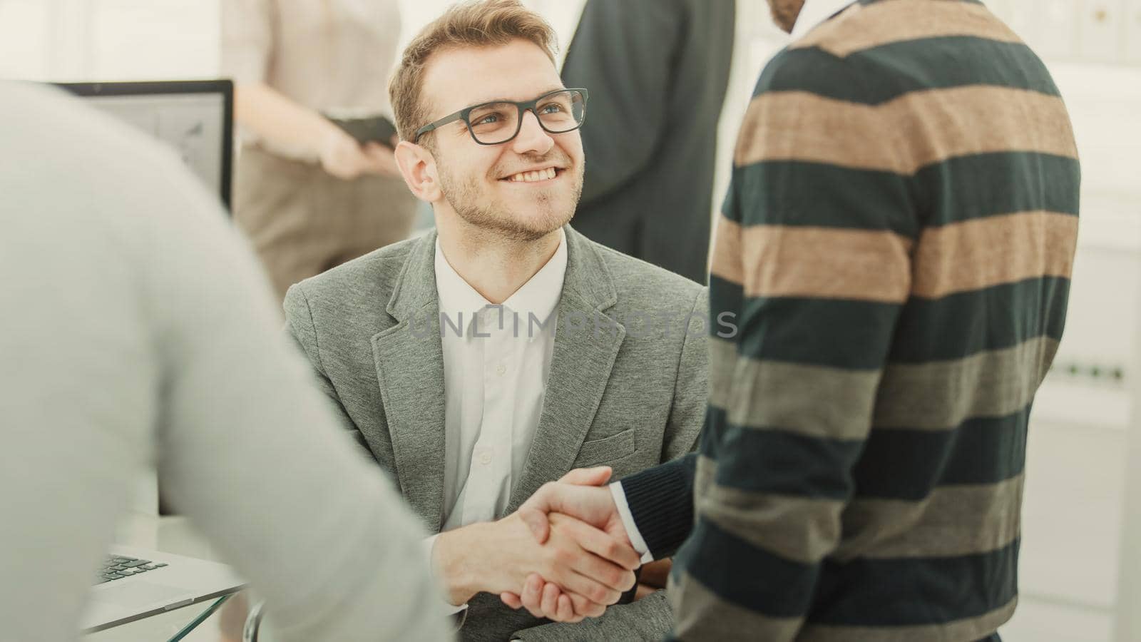 handshake colleagues from the business team near the workplace in the modern office.