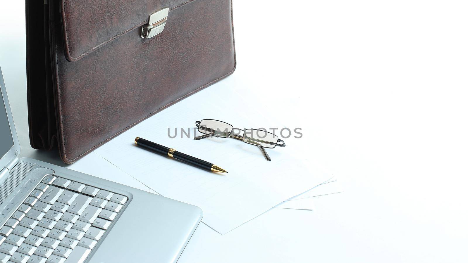 open laptop , briefcase and pen on the desktop by SmartPhotoLab