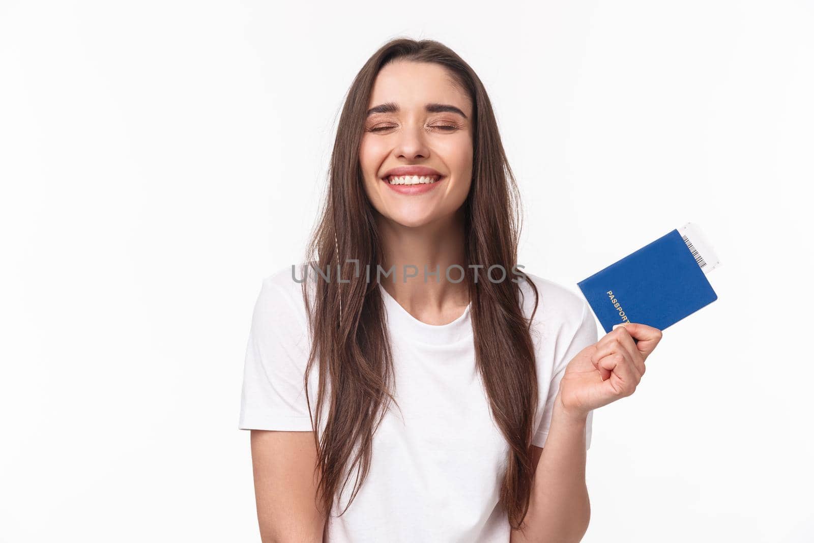 Travelling, holidays, summer concept. Dreamy happy young beautiful girl in white t-shirt, close eyes smiling, daydreaming how she sunbathing near beach on vacation, hold passport with ticket by Benzoix