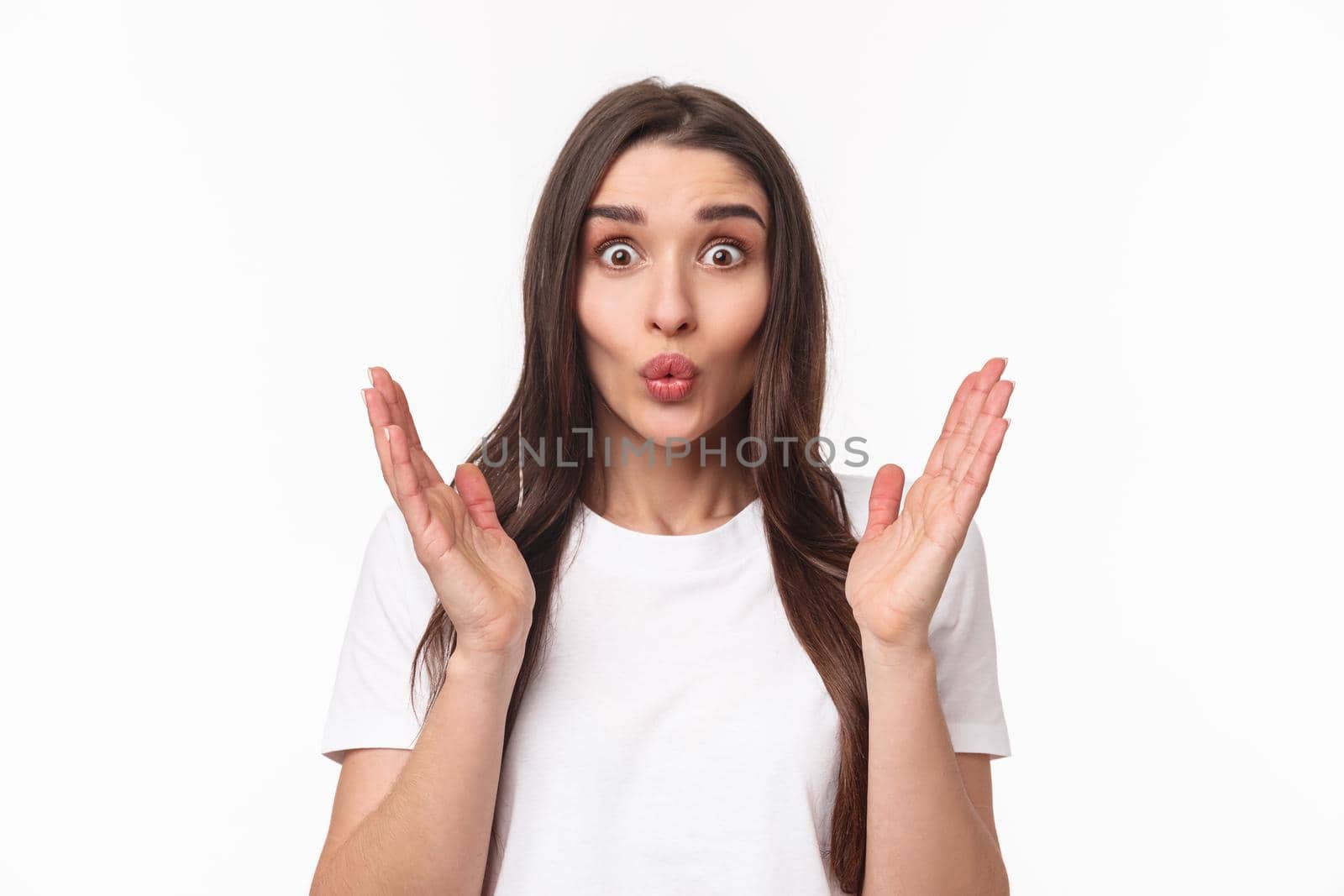 Portrait of happy surprised young woman glad hear friend getting promoted, clasp hands in congratulations, folding lips astonished and excited, smiling stand white background.