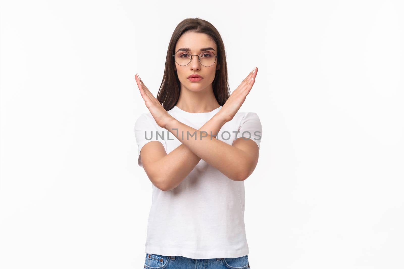 Waist-up portrait of determined, serious-looking young female activist, saying no to women opression, show cross sign in stop motion, look determined, quit something, prohibit or disapprove.