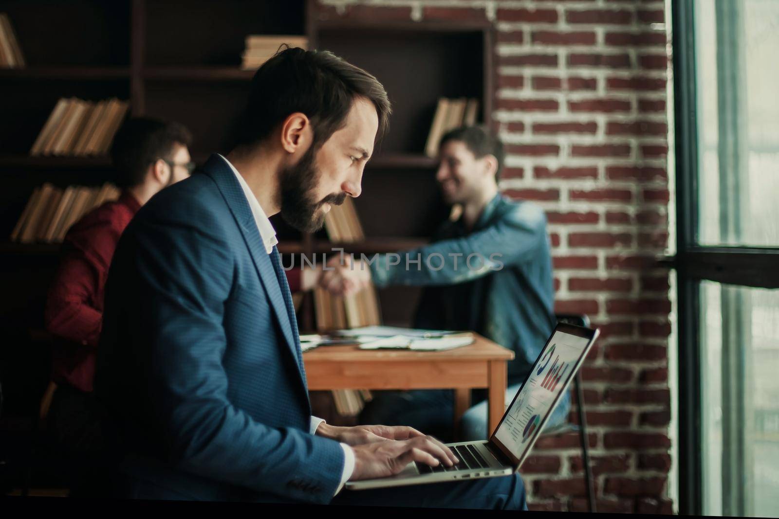 advertising Manager works with the marketing graphics on laptop by SmartPhotoLab