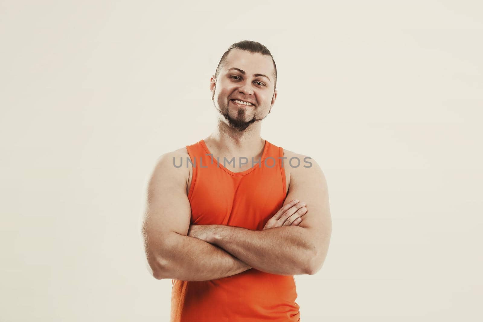 portrait of a sporty guy - bodybuilder in jeans and orange t-shirt by SmartPhotoLab