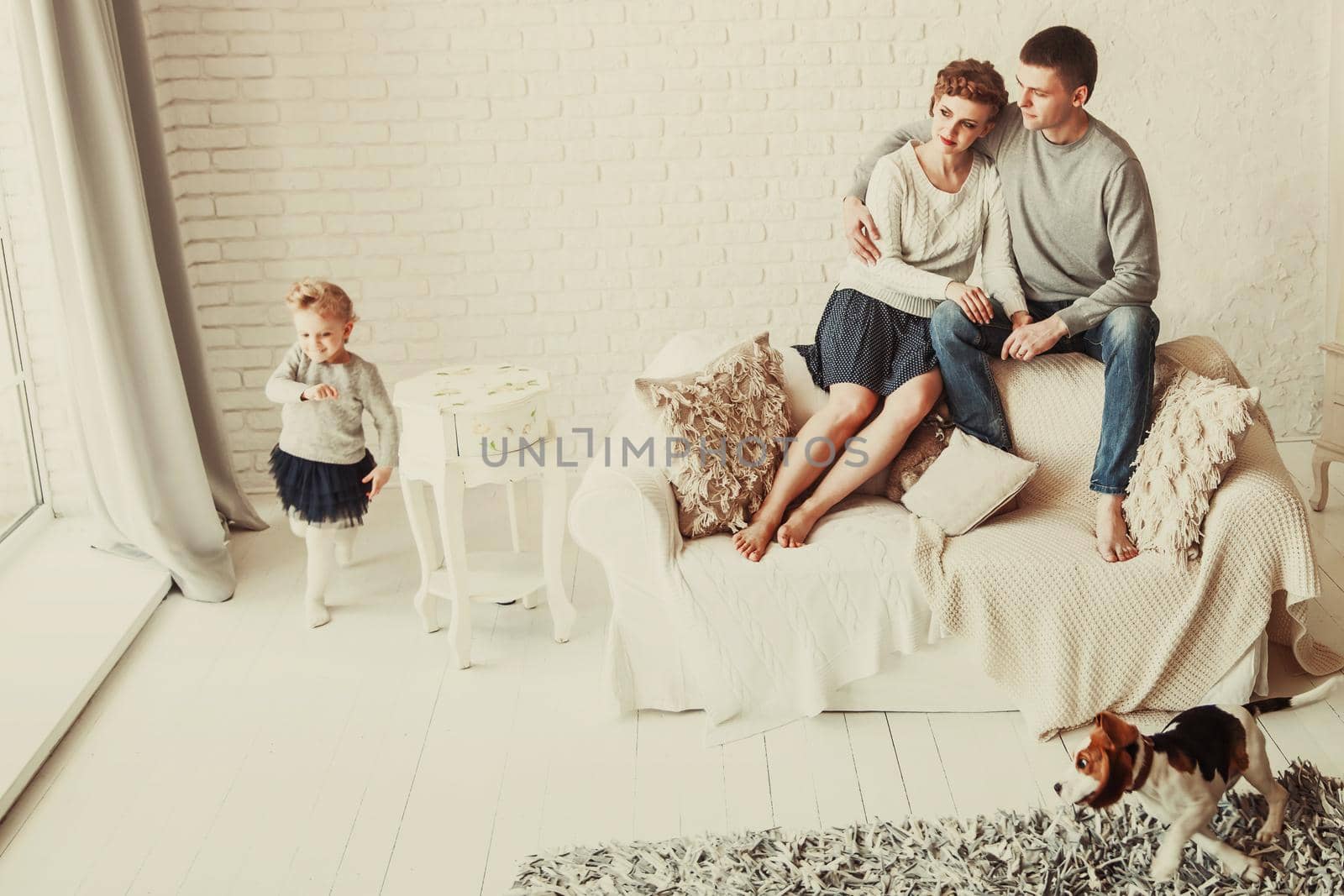 young family resting in living room on Sunday