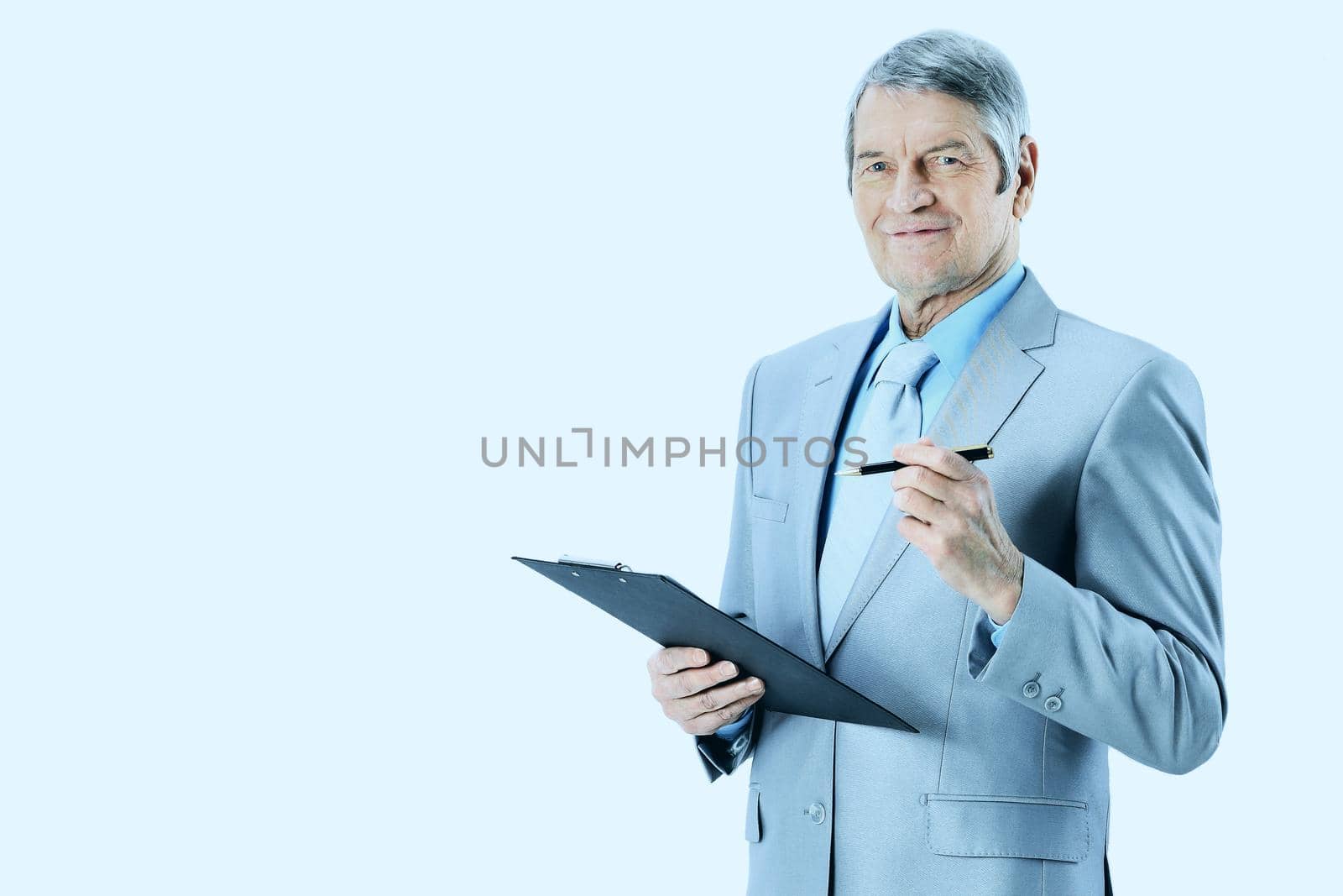 Nice businessman at the age, writes the work plan. Isolated on a white background.