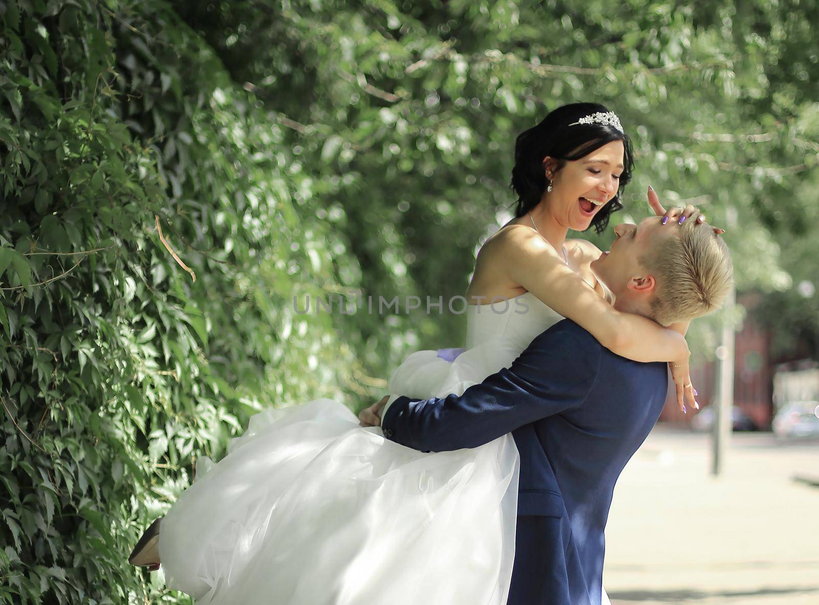 funny bride and groom embracing on the street by SmartPhotoLab