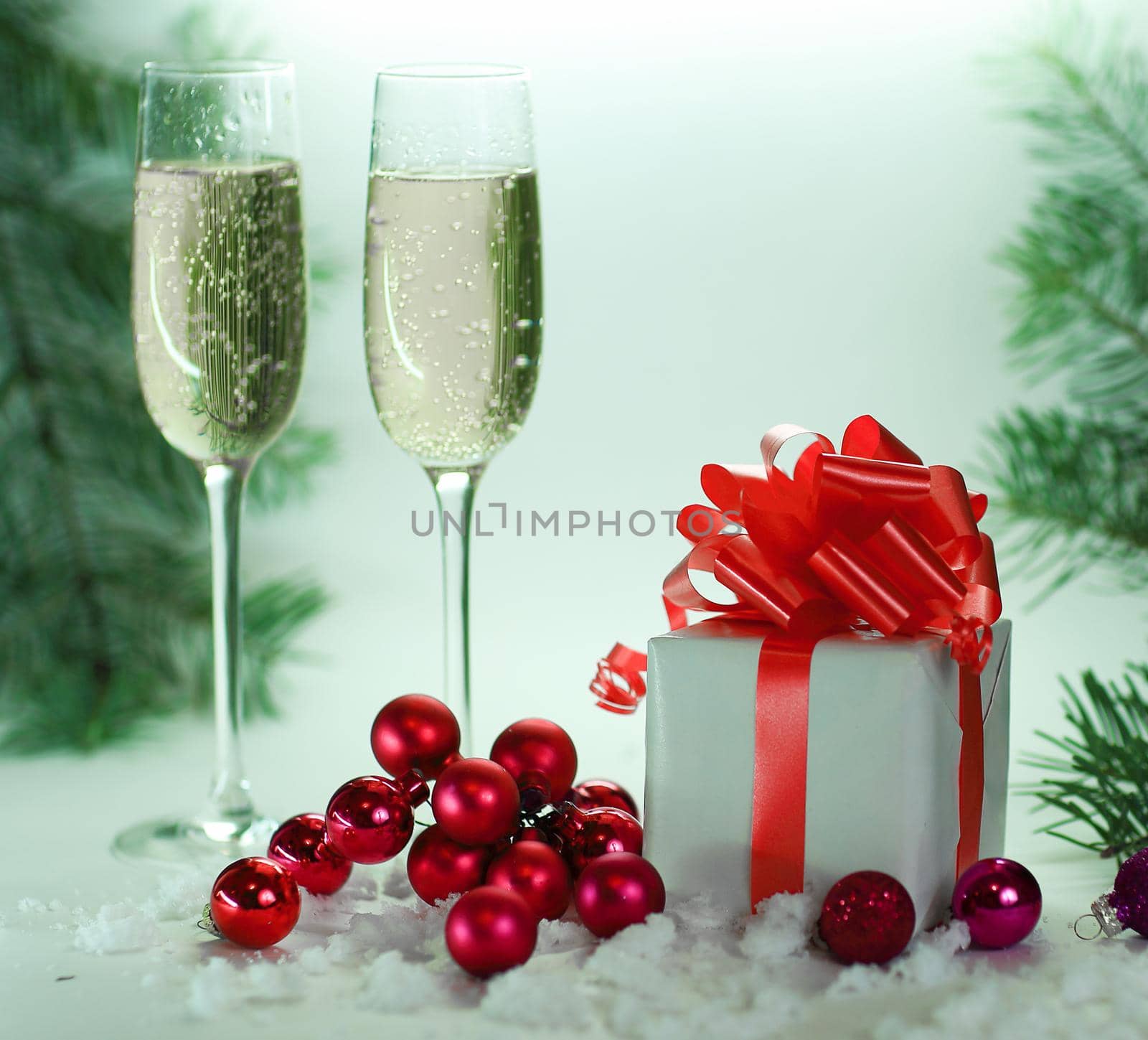 two glasses with champagne, and boxes with gifts on Christmas background .photo with copy space.