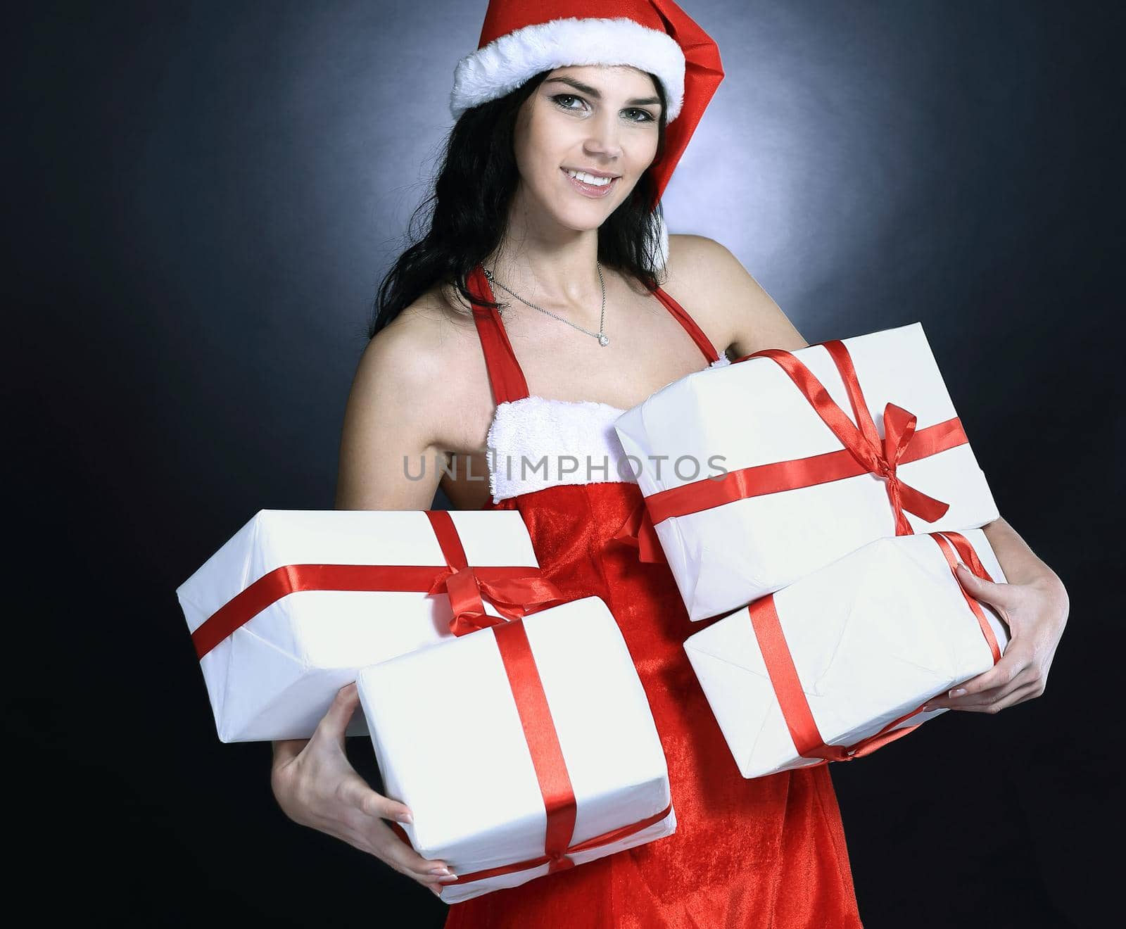 happy young woman in costume of Santa Claus with lots of Christmas shopping. isolated on black