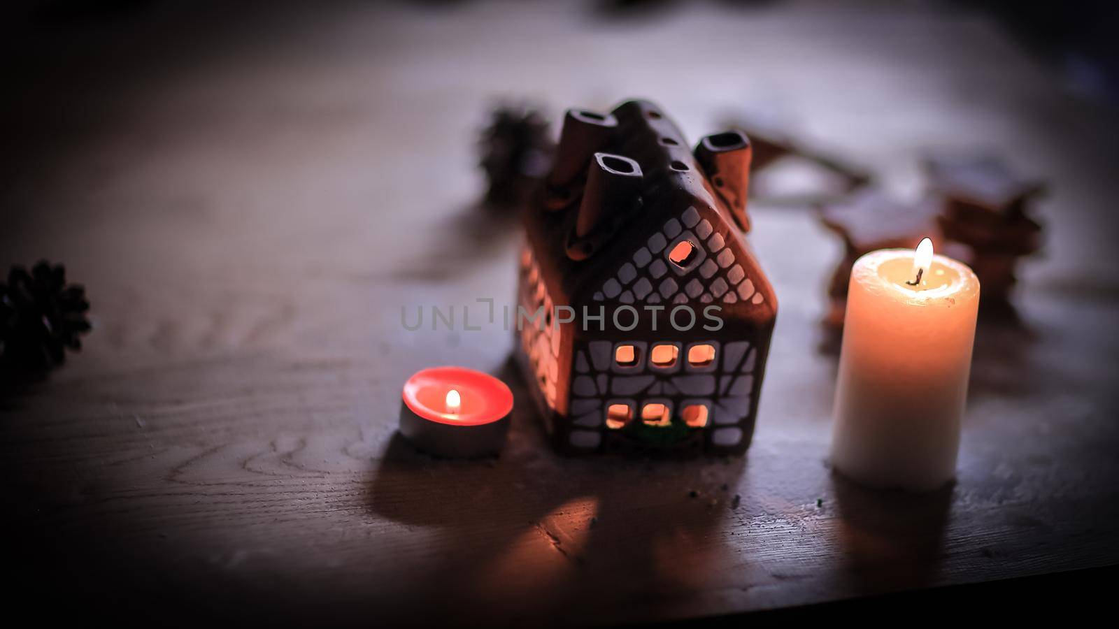 gingerbread house candle on blurred background of the table.photo with copy space