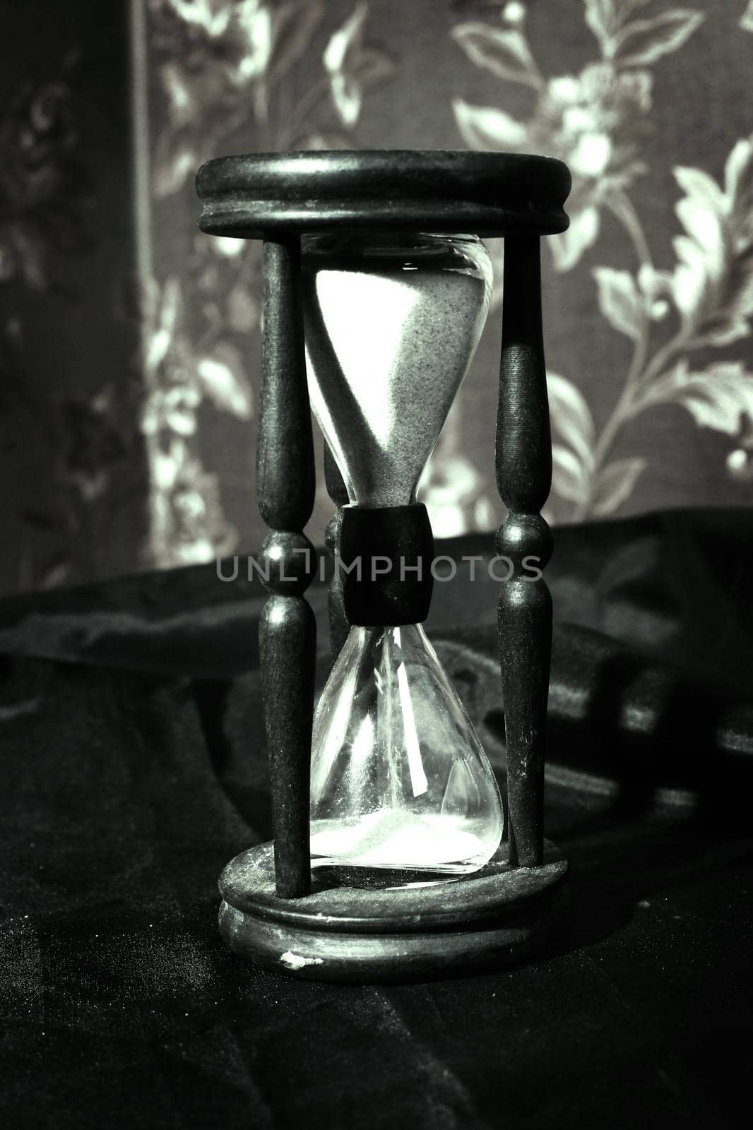closeup.hourglass with white sand on a wooden table. photo with copy space