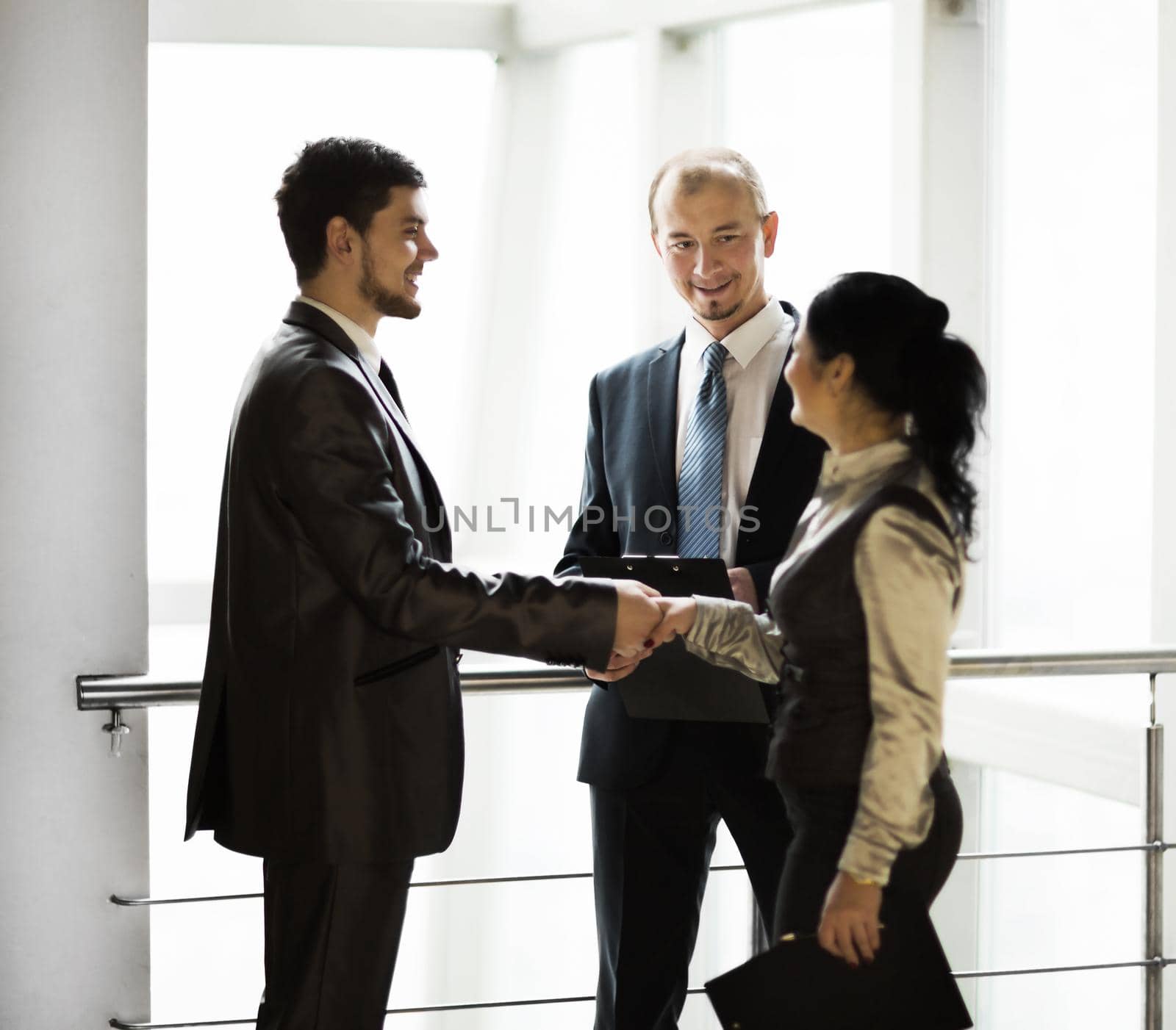 image business team, meeting with a handshake in the lobby of the business center by SmartPhotoLab