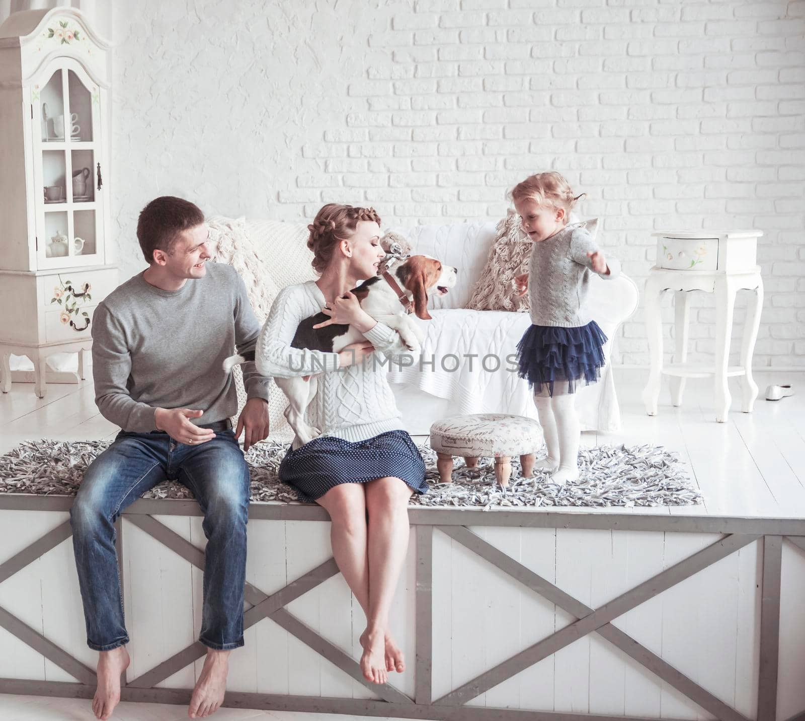 portrait of a happy family and their pet in a cozy living room by SmartPhotoLab