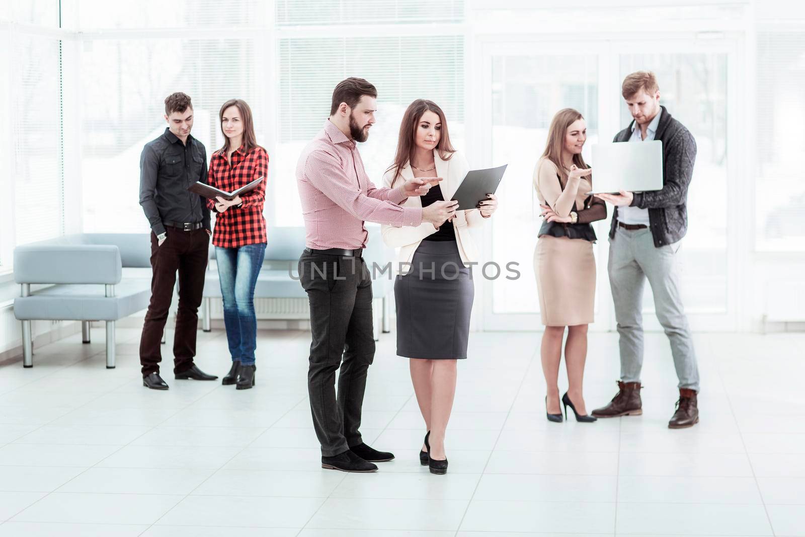 business team with laptop and documents standing in the lobby of the office before a business meeting