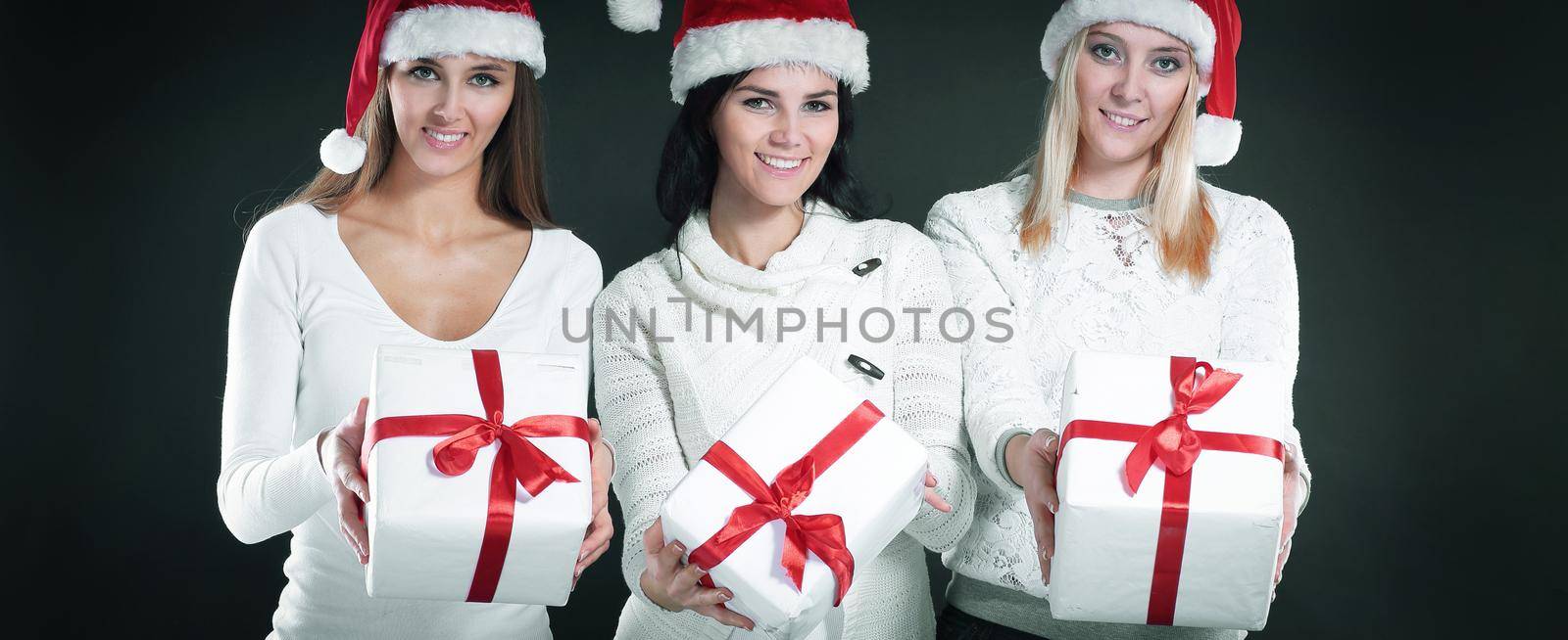 three young women in costume of Santa Claus with Christmas shop by SmartPhotoLab