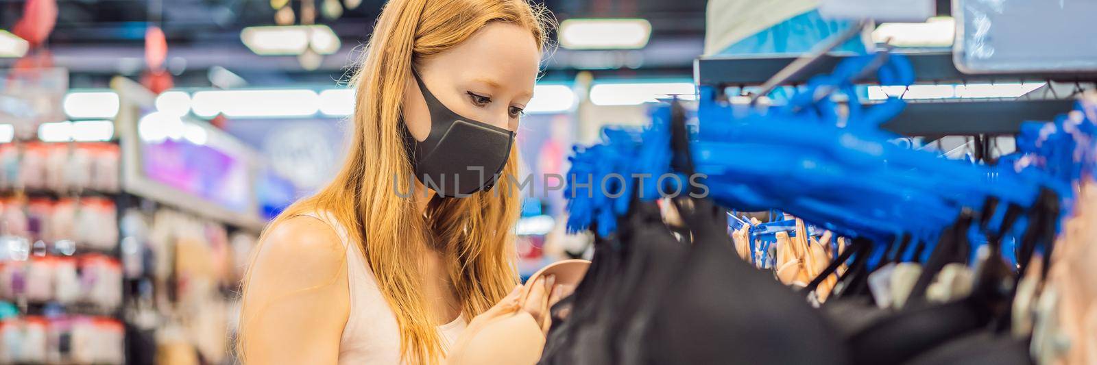 Woman in a clothing store in a medical mask because of a coronovirus. Quarantine is over, now you can go to the clothing store BANNER, LONG FORMAT by galitskaya