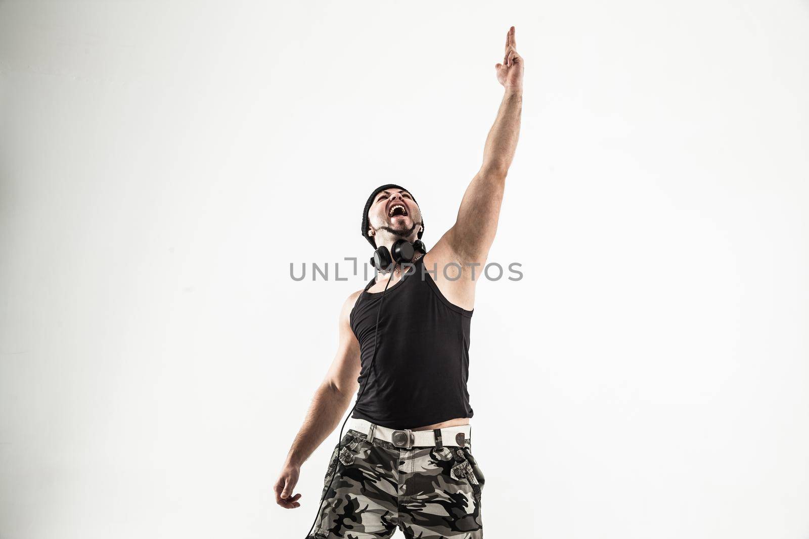 emotional and charismatic DJ - rapper with headphones on a light by SmartPhotoLab