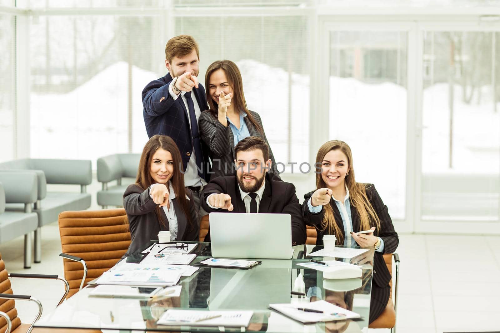 concept of success in business: professional business team near the workplace with your fingers pointing forward. by SmartPhotoLab