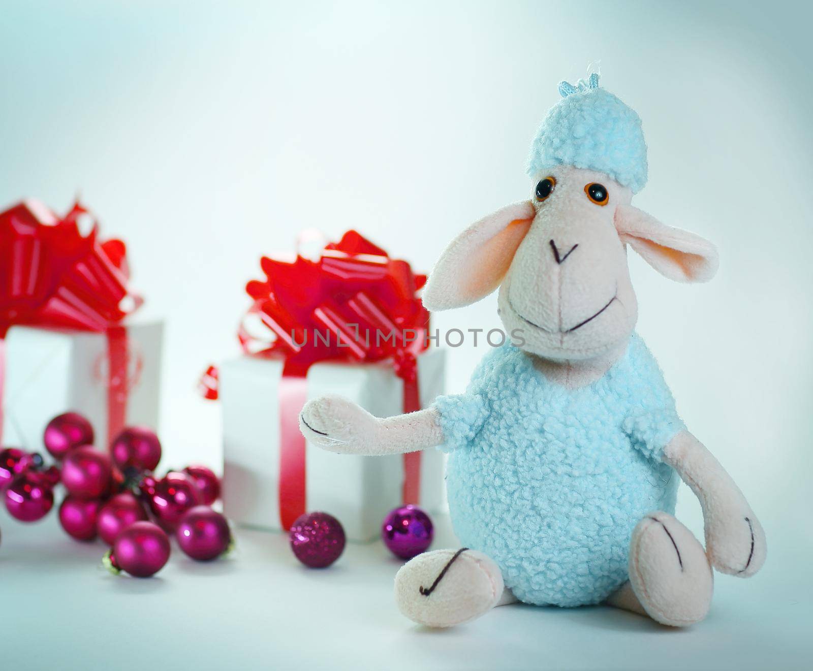 Christmas gifts and a toy sheep .isolated on white background by SmartPhotoLab