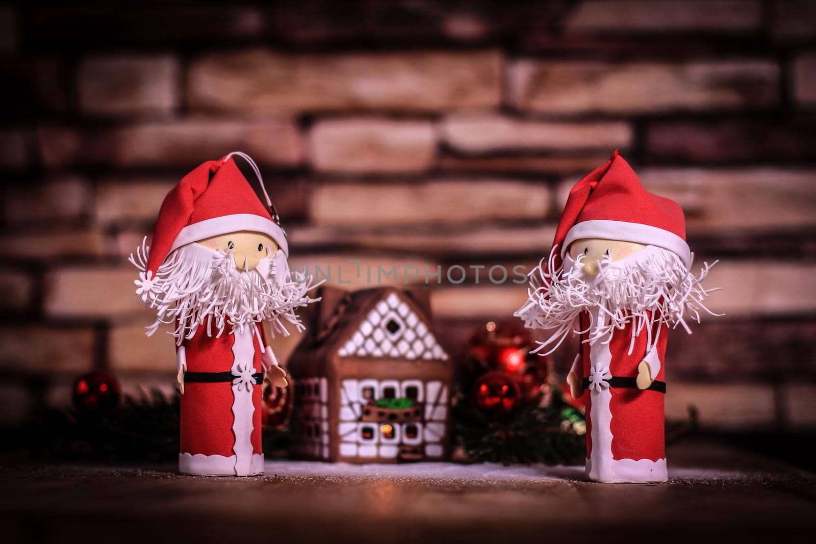 two funny Santa Claus on the background of a gingerbread house. by SmartPhotoLab