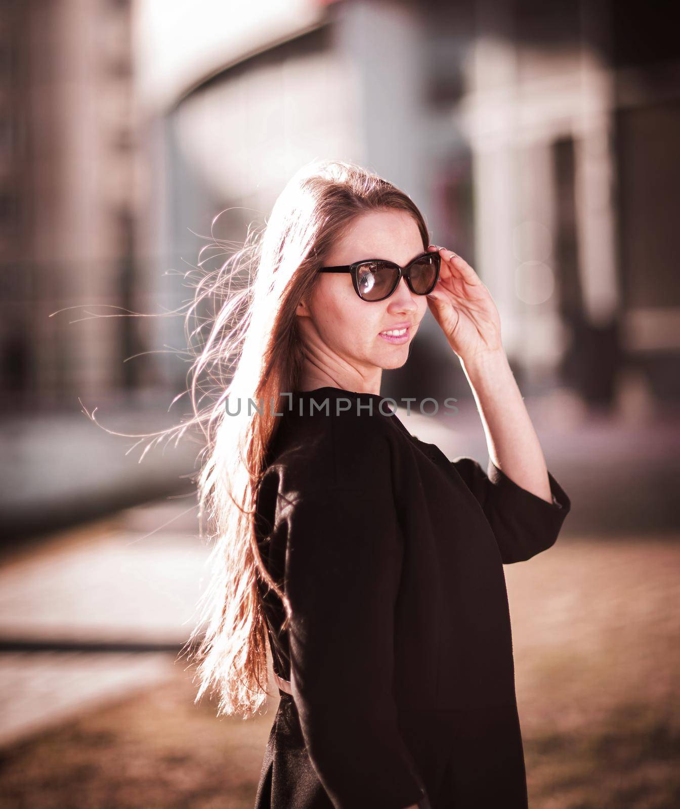 Confident business woman wearing sunglasses on the background of a business center.photo has empty space for your text